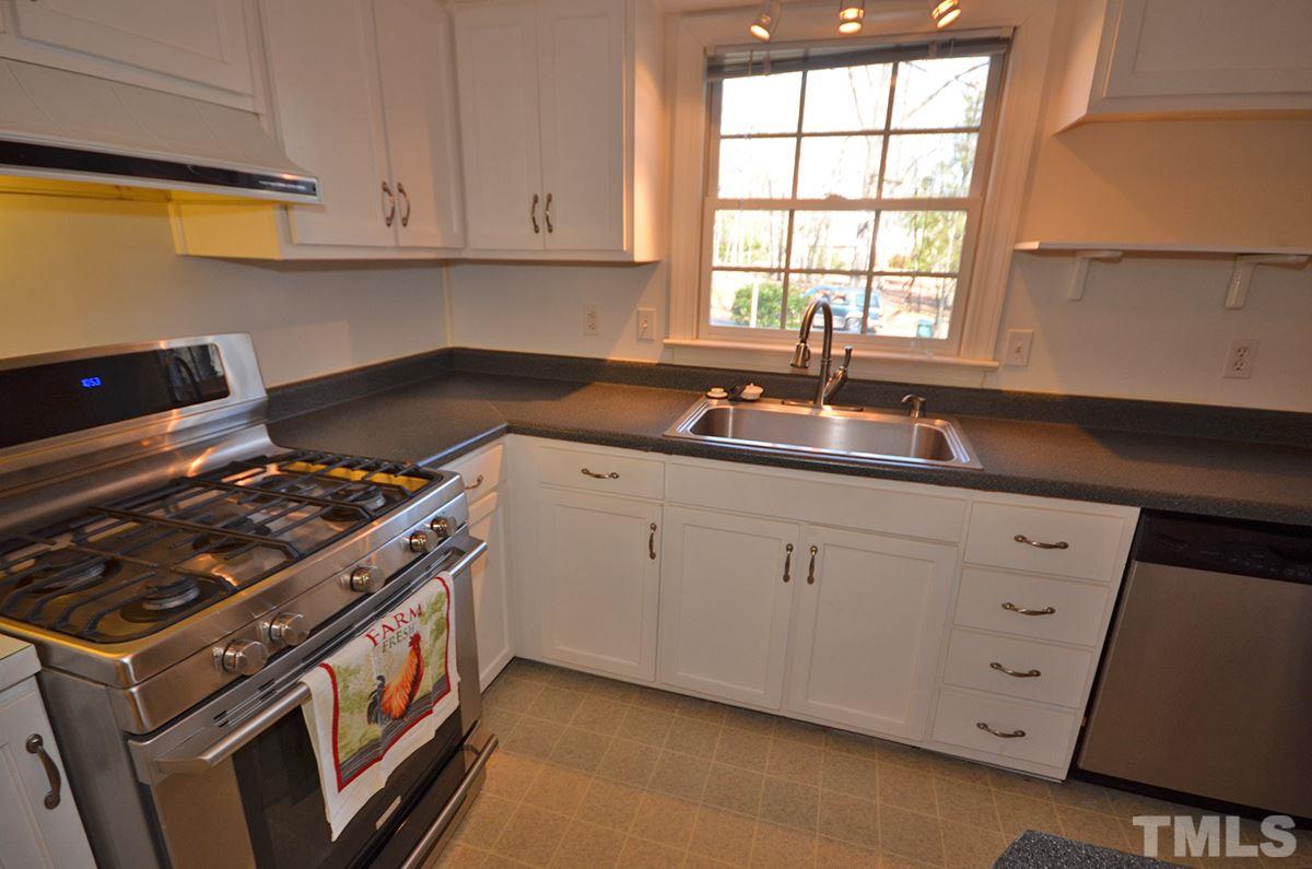 4905 Revere Road Durham, NC 27713 - Photo 8 of 24 a kitchen with white cabinets and a stove top oven