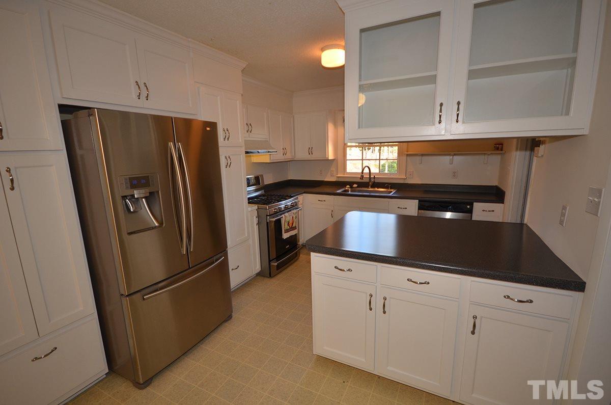 4905 Revere Road Durham, NC 27713 - Photo 9 of 24 a kitchen with stainless steel appliances a refrigerator a sink a stove and cabinets