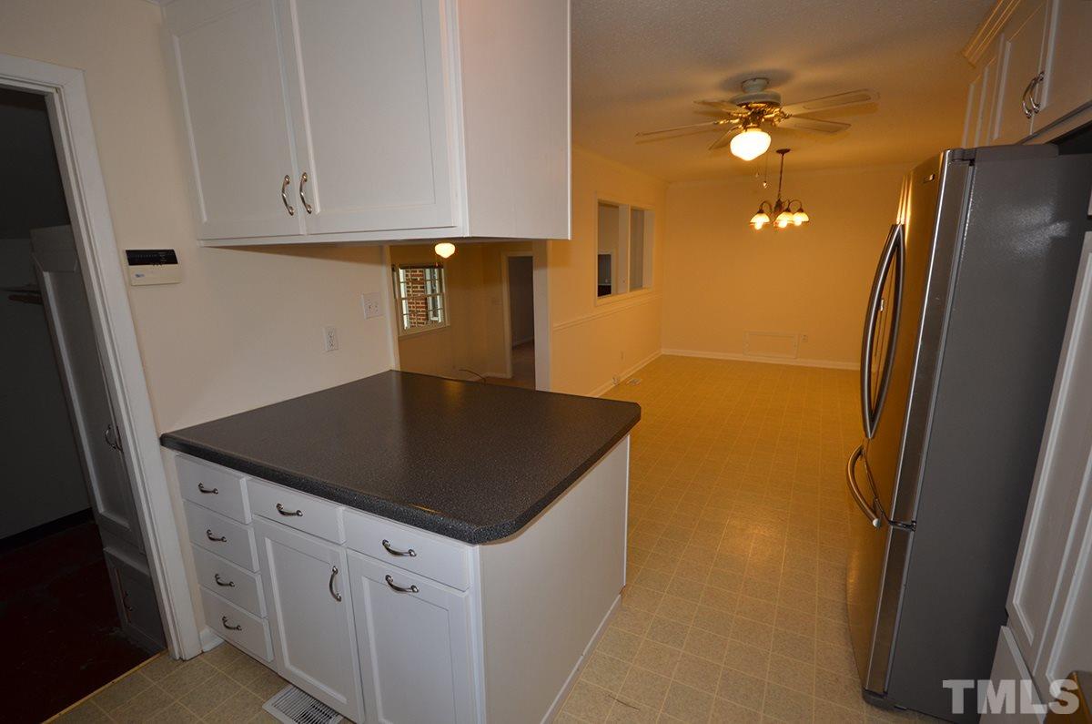 4905 Revere Road Durham, NC 27713 - Photo 10 of 24 a kitchen with stainless steel appliances granite countertop a refrigerator a sink a stove and island