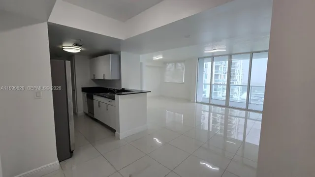 a kitchen with granite countertop a stove a sink and a refrigerator