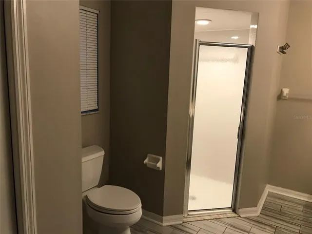a white toilet sitting next to a shower
