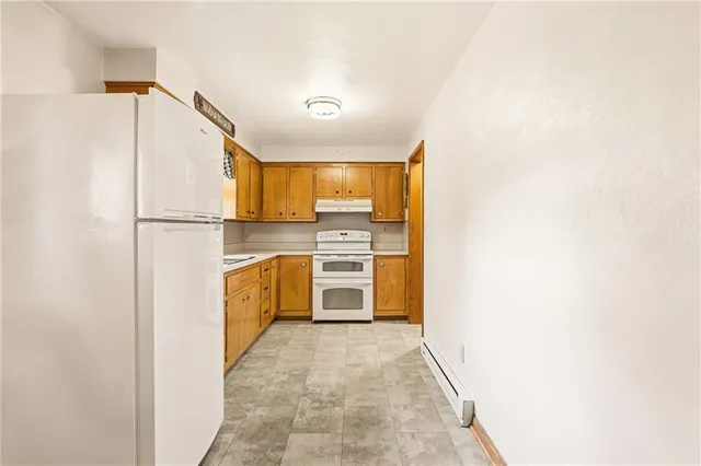 a kitchen with a refrigerator a stove top oven a counter space and cabinets