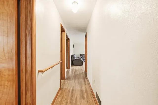 a view of a hallway with wooden floor and staircase