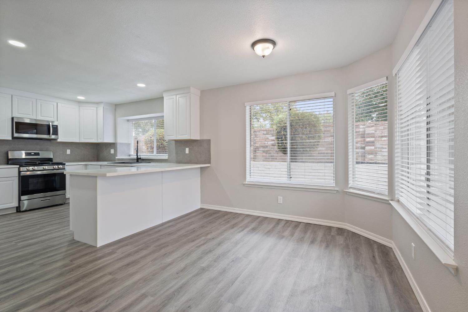 7300 Saltgrass Way Elk Grove, CA 95758 - Photo 15 of 35 a kitchen with wooden floors white cabinets and appliances