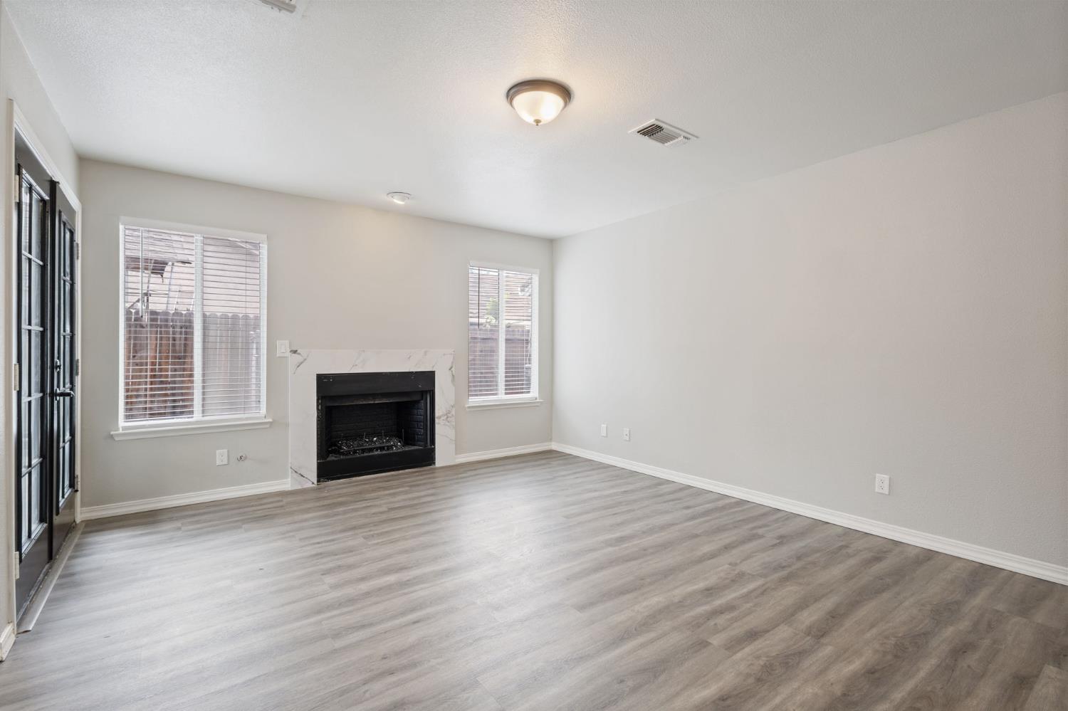 7300 Saltgrass Way Elk Grove, CA 95758 - Photo 16 of 35 a view of empty room with wooden floor and fireplace