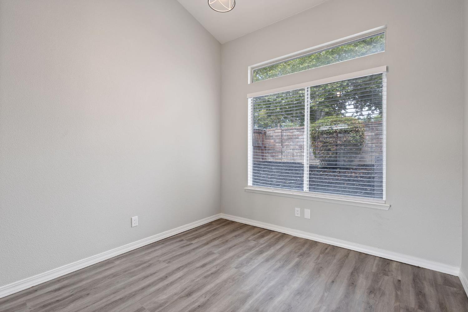 7300 Saltgrass Way Elk Grove, CA 95758 - Photo 8 of 35 a view of an empty room with wooden floor and a window