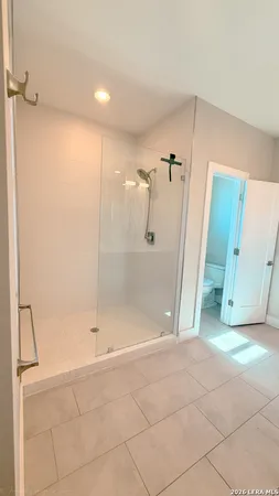 a bathroom with a shower and a glass door