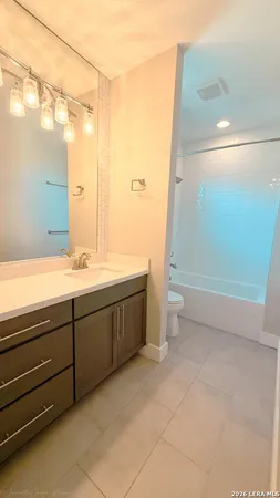 a bathroom with a double vanity sink toilet and shower
