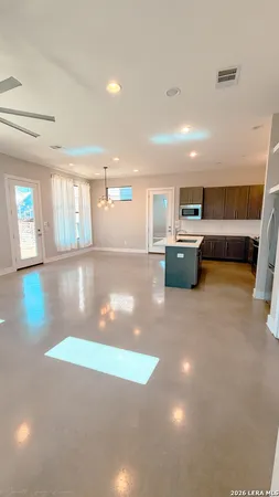 a living room with furniture and a dining table with kitchen view