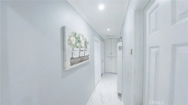 a view of a hallway with wooden floor and a bathroom