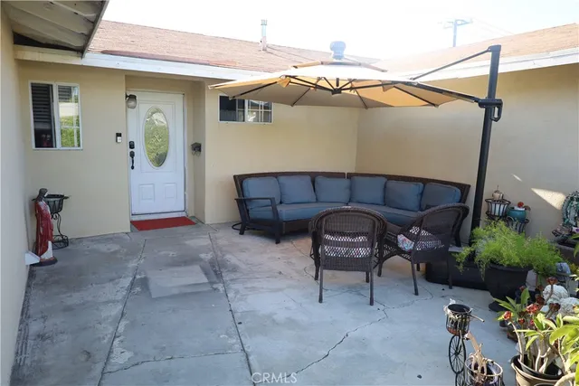 a view of a patio with table and chairs under an umbrella