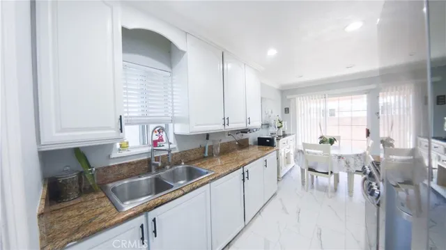 a kitchen filled counter top space a sink cabinets and a window