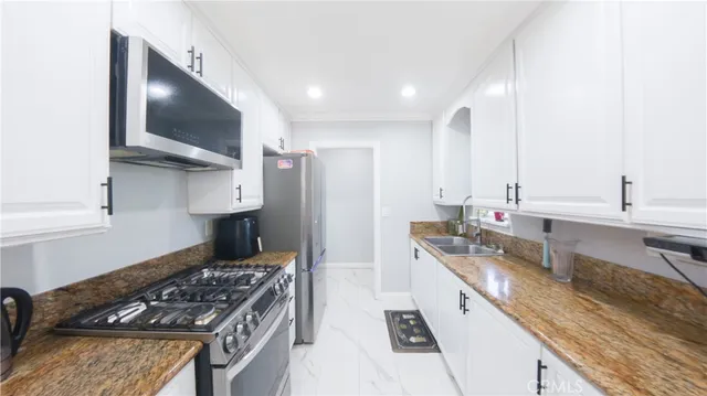 a kitchen with stainless steel appliances granite countertop a sink stove and refrigerator