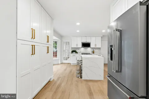 a kitchen with granite countertop white cabinets and white appliances
