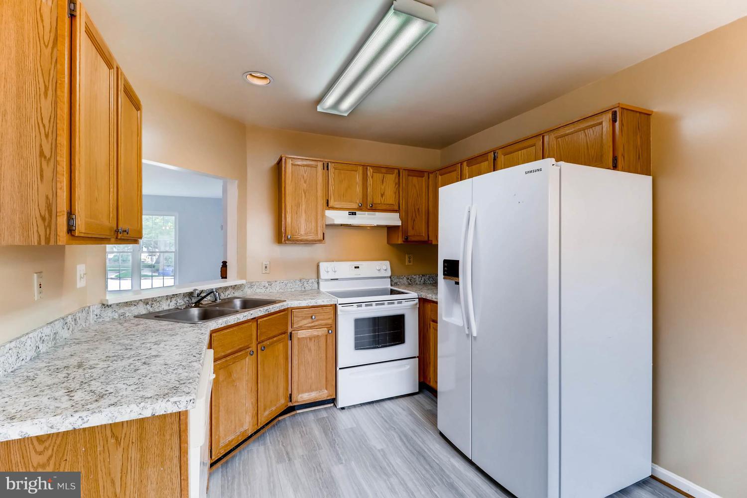 4414 Cole Farm Road Baltimore, MD 21236 - Photo 11 of 30 a kitchen with a sink a refrigerator a microwave and cabinets