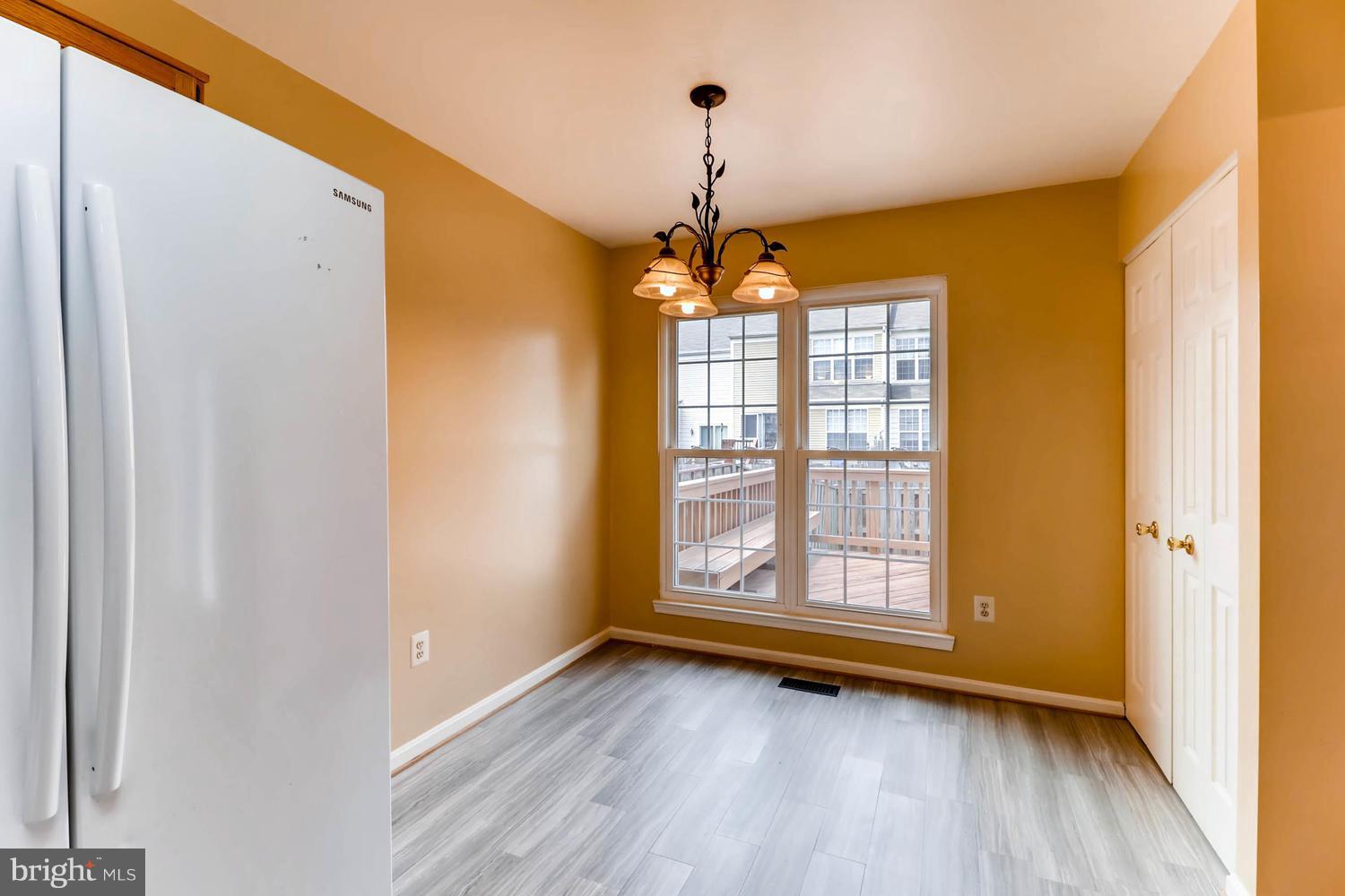 4414 Cole Farm Road Baltimore, MD 21236 - Photo 12 of 30 a view of an empty room with wooden floor and a window