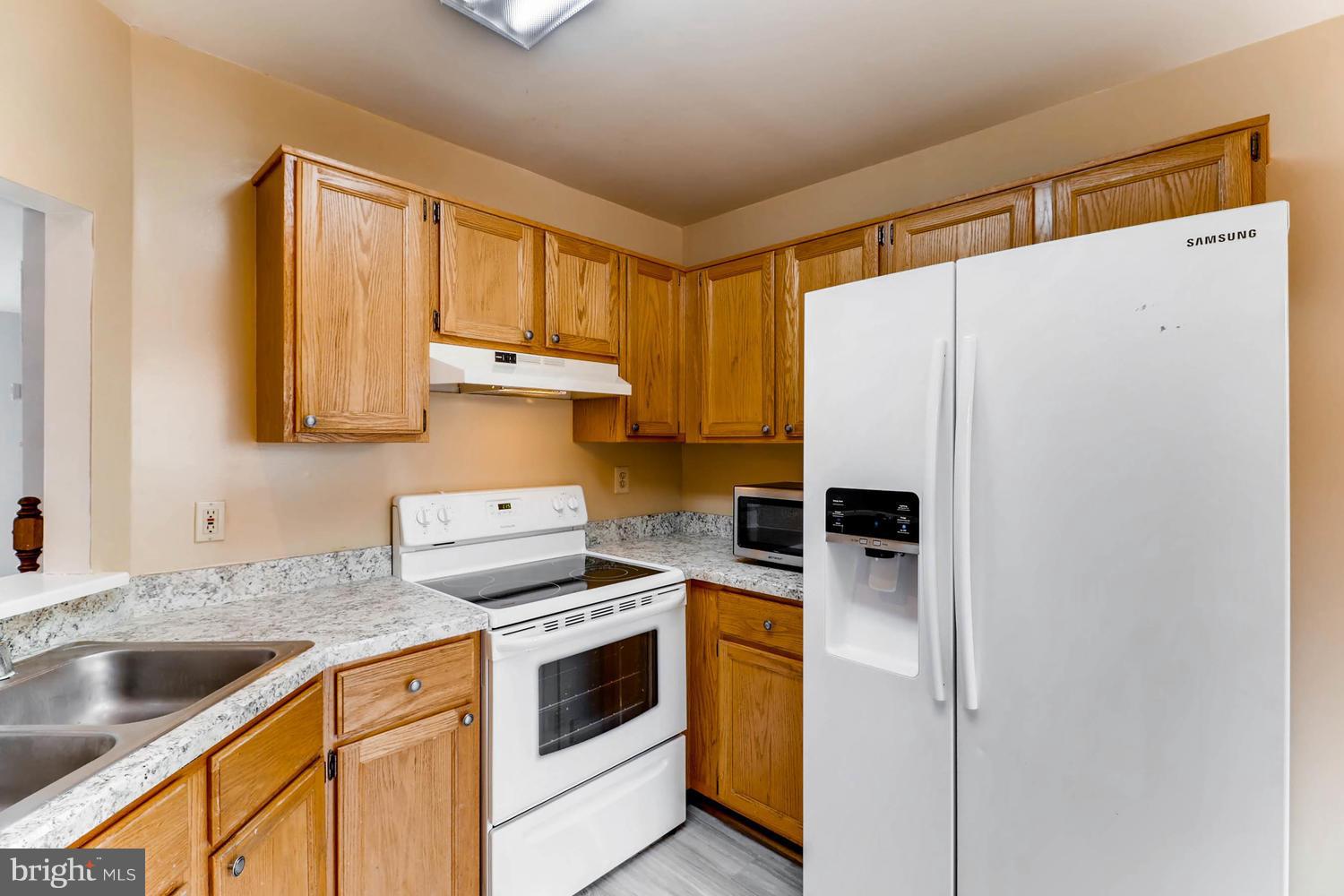 4414 Cole Farm Road Baltimore, MD 21236 - Photo 13 of 30 a kitchen with a refrigerator sink and stove