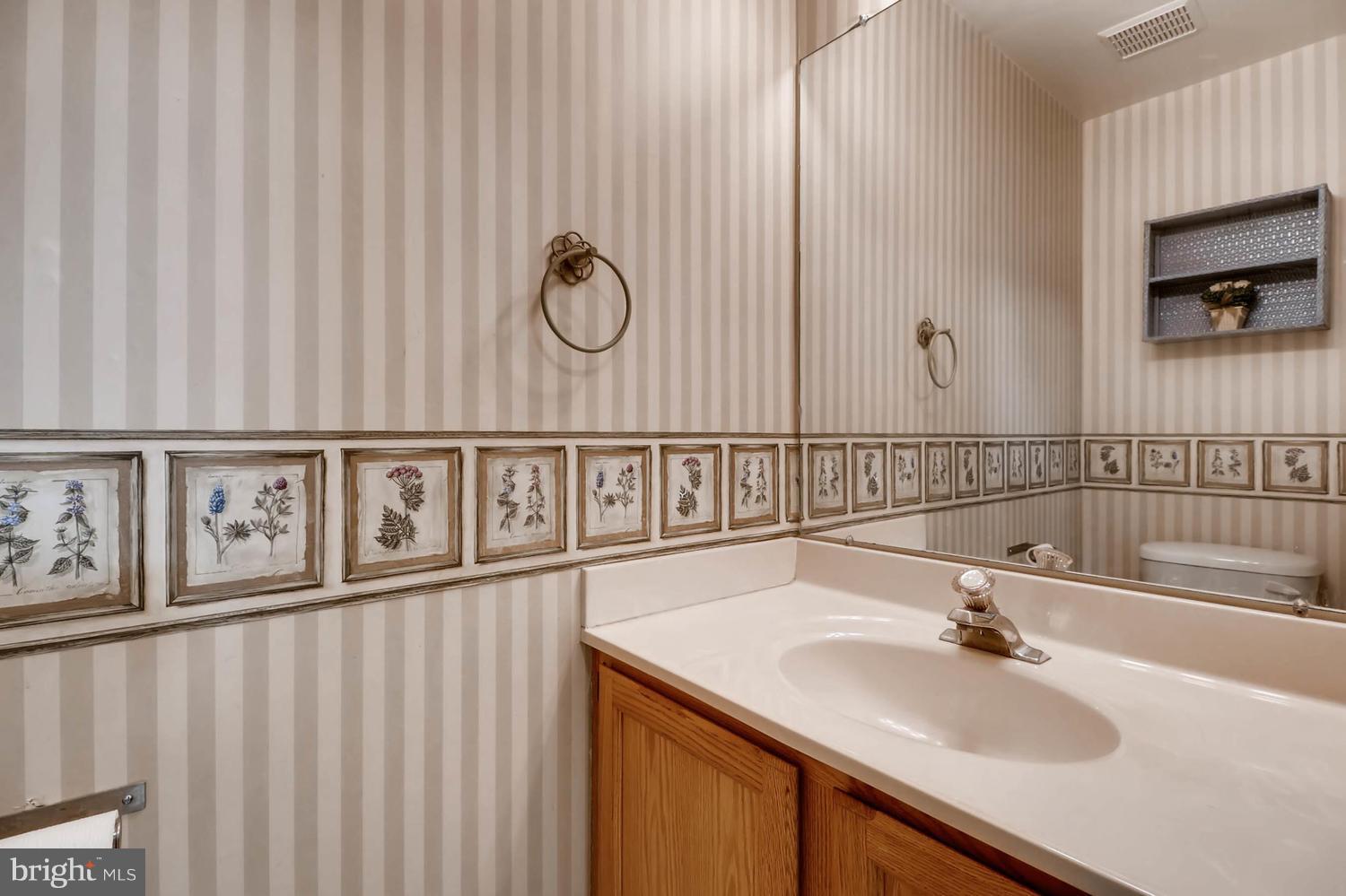 4414 Cole Farm Road Baltimore, MD 21236 - Photo 14 of 30 a bathroom with a sink and a mirror