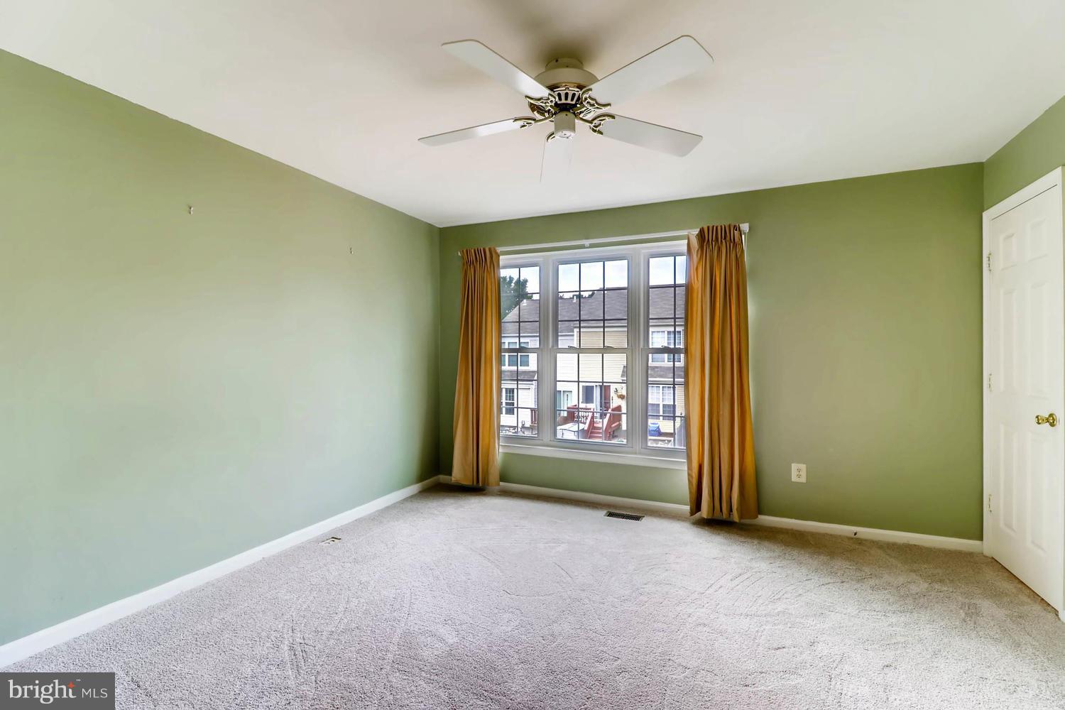 4414 Cole Farm Road Baltimore, MD 21236 - Photo 15 of 30 an empty room with a ceiling fan and windows