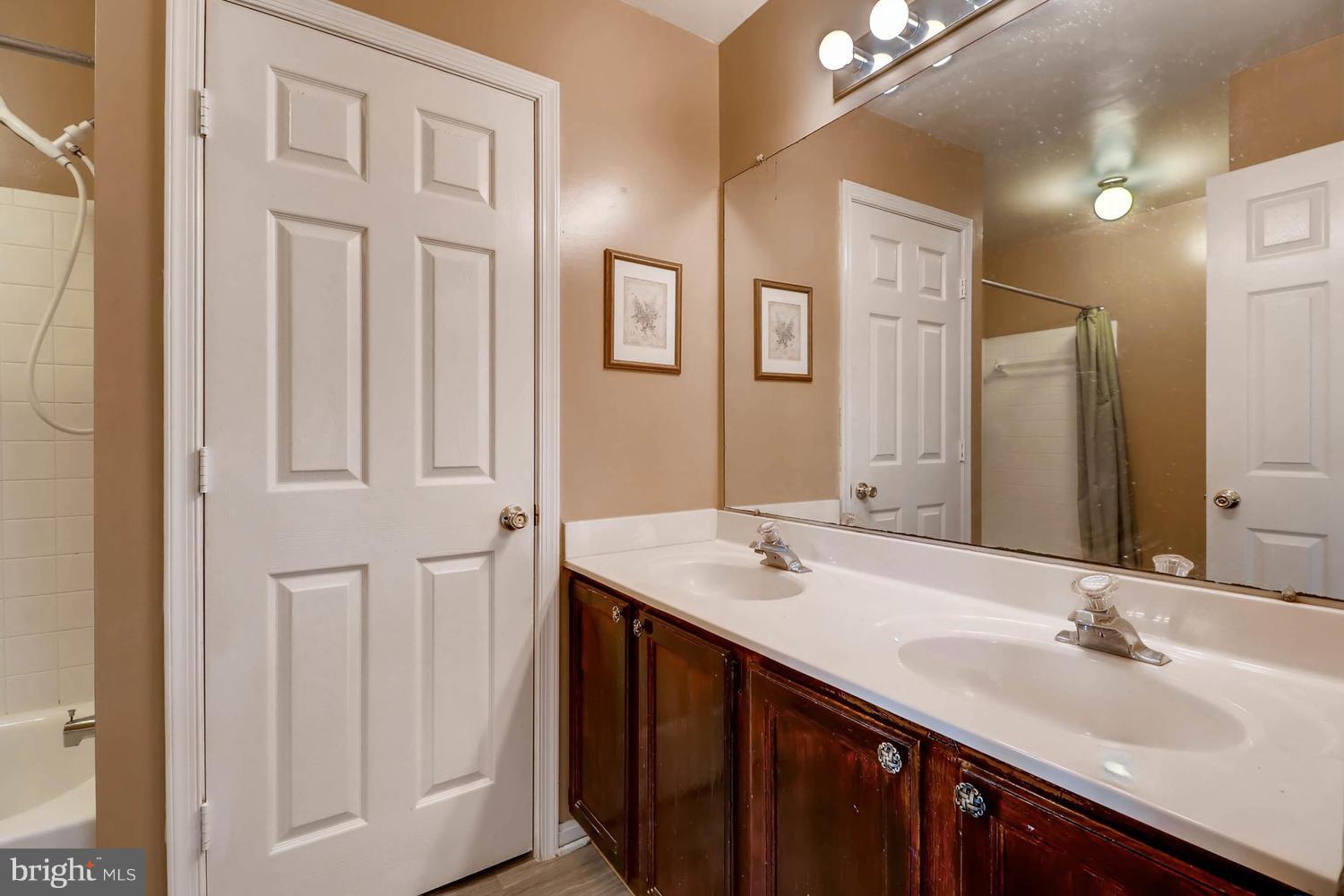 4414 Cole Farm Road Baltimore, MD 21236 - Photo 19 of 30 a bathroom with a double vanity sink and a mirror