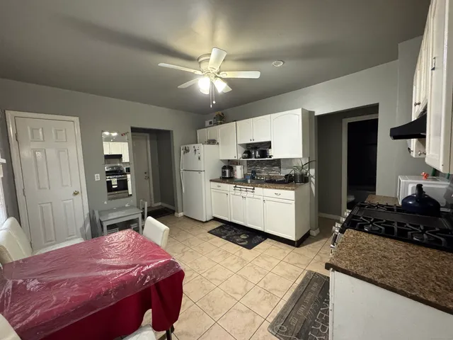 a kitchen with stainless steel appliances kitchen island granite countertop a stove refrigerator and cabinets
