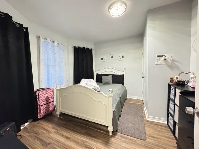 a room with a bed and wooden floor