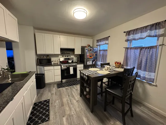 a kitchen with a table chairs a sink dishwasher and cabinets