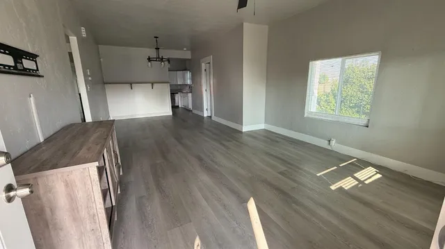 a view of empty room with wooden floor and window