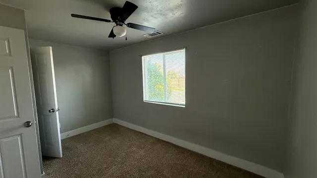 a view of a livingroom with a ceiling fan and window