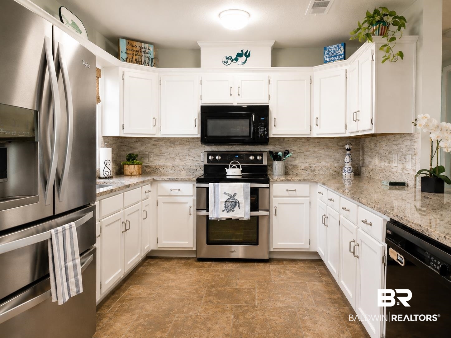 21733 Sedlack Road Silverhill, AL 36576 - Photo 13 of 22 U-shaped kitchen featuring white cabinetry, granite-finish countertops, and a full suite of stainless steel and black appliances