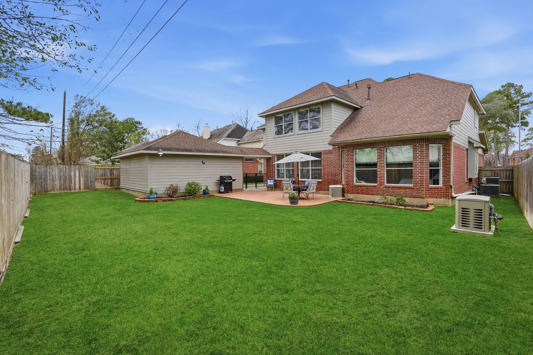 2515 Woodsboro Drive Spring, TX 77388 - Photo 39 of 44 This spacious backyard features a well-maintained lawn, a patio area with outdoor seating, and and large windows. No back neighbors provide privacy. This is a great space for outdoor activities or even a pool!
