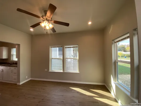 an empty room with windows and fan