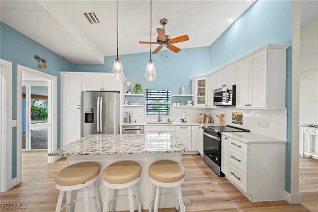 a kitchen with kitchen island granite countertop a sink and stainless steel appliances