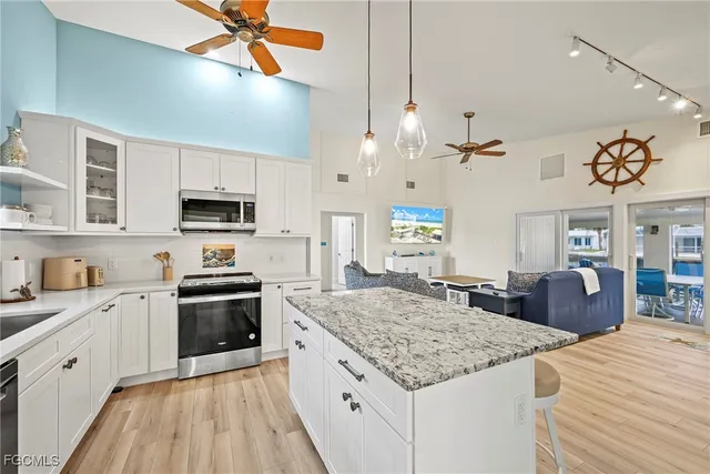 a kitchen with stainless steel appliances kitchen island granite countertop a stove and cabinets