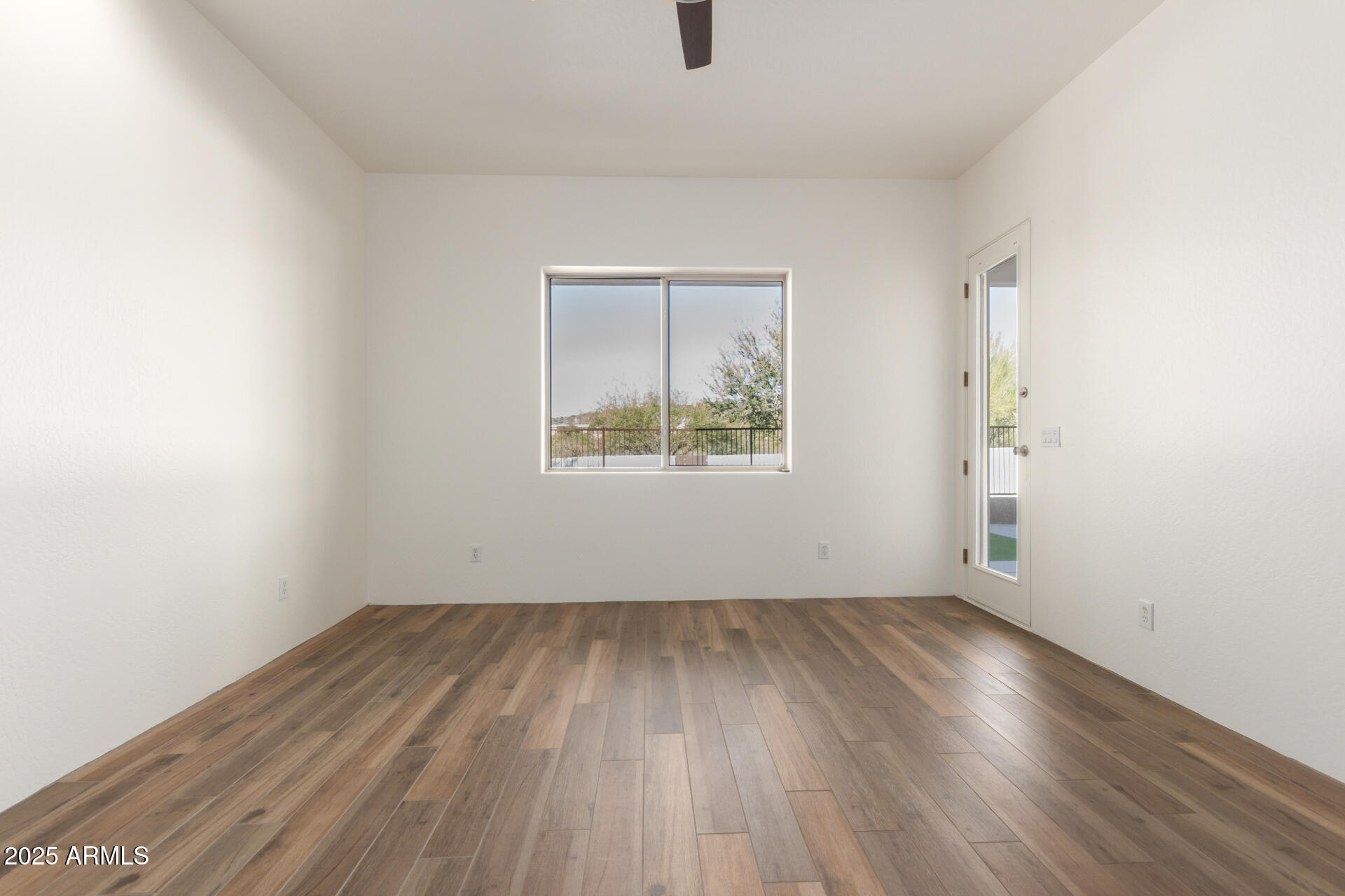 1540 East Circle Mountain Road New River, AZ 85087 - Photo 37 of 65 an empty room with wooden floor and windows