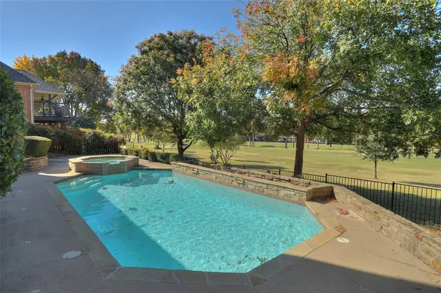 a view of a swimming pool with a patio and a yard