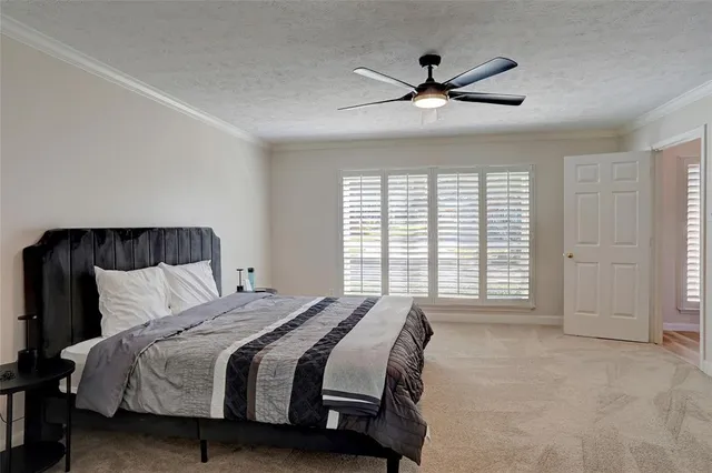 a bedroom with a large bed and a ceiling fan