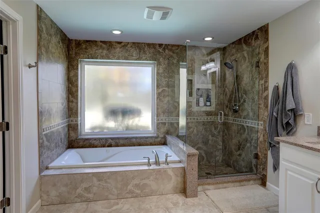 a bathroom with a bathtub a shower and a sink