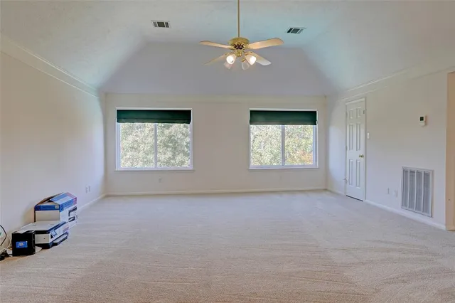 an empty room with windows and fan