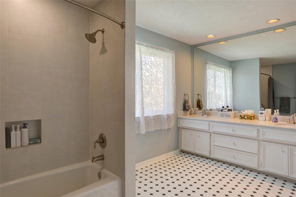 2905 Wyndham Lane Richardson, TX 75082 - Photo 21 of 27 a bathroom with a double vanity sink toilet mirror and bathtub