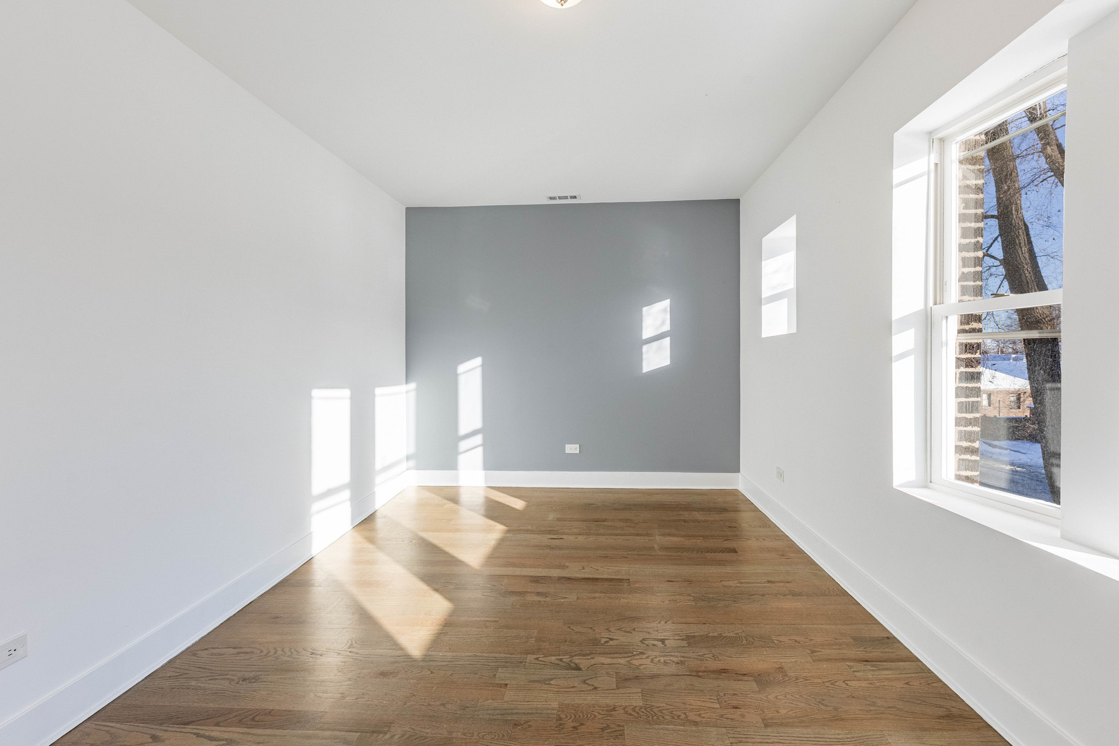 2038 East 73rd Street Chicago, IL 60649 - Photo 25 of 28 a view of an empty room with window and wooden floor