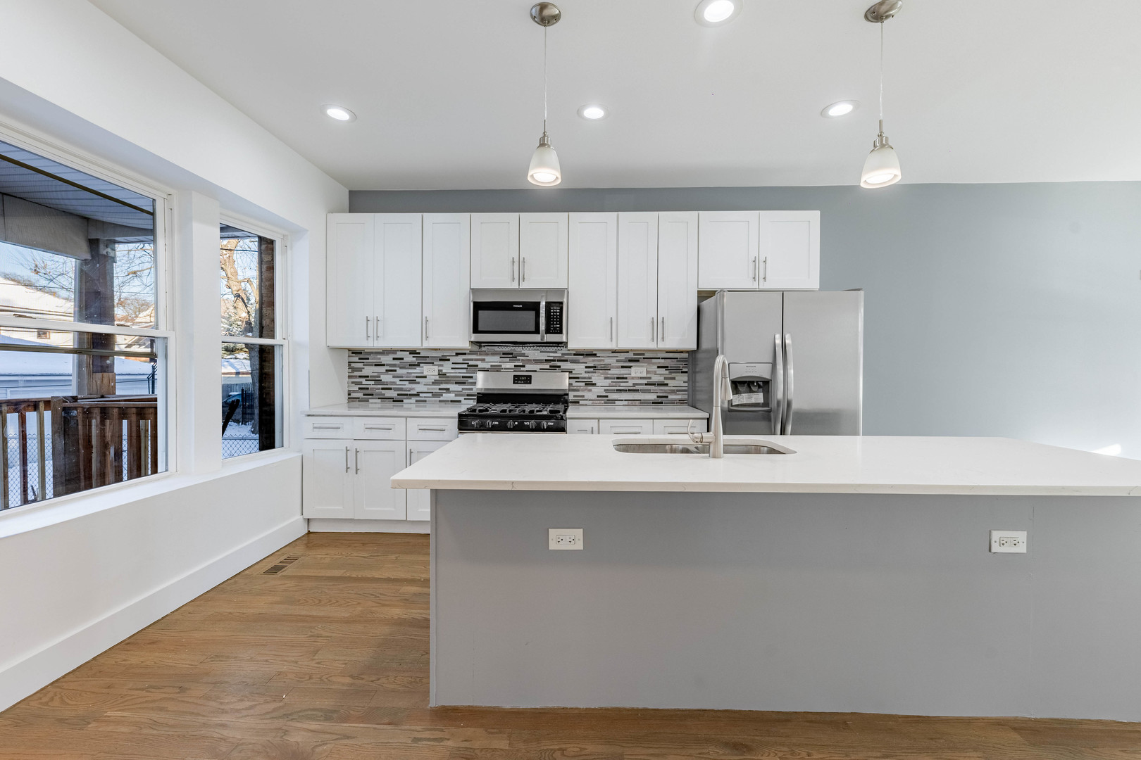 2038 East 73rd Street Chicago, IL 60649 - Photo 8 of 28 a kitchen with stainless steel appliances a refrigerator a stove a sink a center island and a refrigerator
