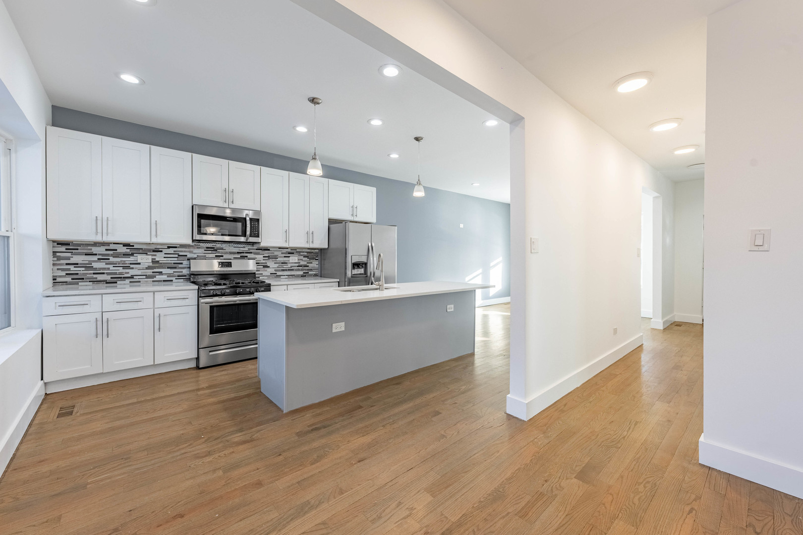2038 East 73rd Street Chicago, IL 60649 - Photo 10 of 28 a large kitchen with stainless steel appliances granite countertop a stove a sink and a refrigerator