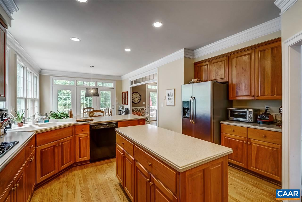3465 Darby Road Keswick, VA 22947 - Photo 19 of 48 a kitchen with stainless steel appliances granite countertop a stove a refrigerator a sink a dining table and chairs