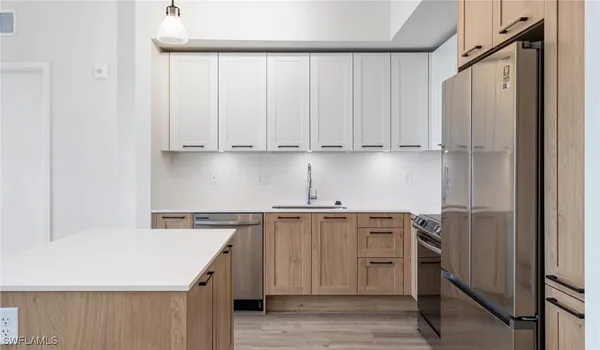 a kitchen with stainless steel appliances a microwave sink refrigerator and cabinets