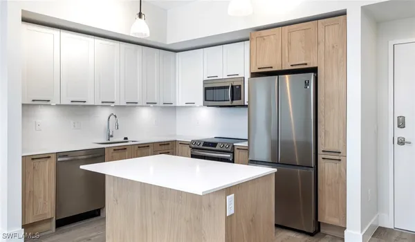 a kitchen with stainless steel appliances granite countertop a refrigerator sink and stove