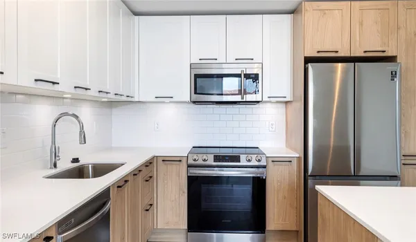 a kitchen with stainless steel appliances a refrigerator and a stove top oven