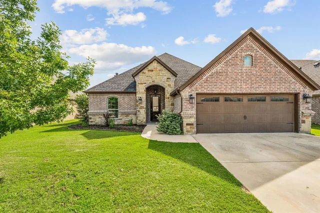 a front view of a house with yard and green space