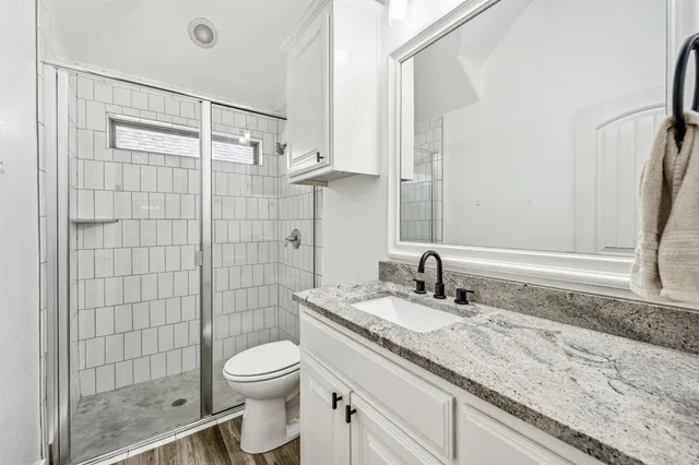 a bathroom with a granite countertop sink toilet and shower