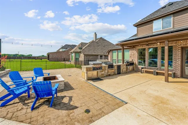 a view of a patio with couches table and chairs under an umbrella